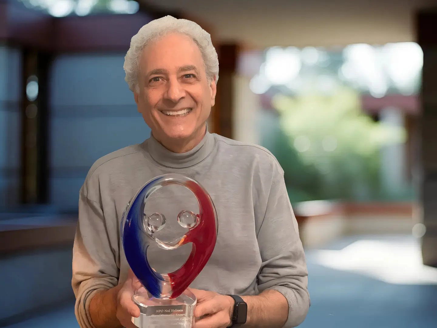 Dr Richard Warshak holding his Ned Holstein Award in his home office